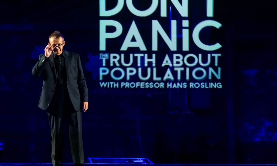 Hans Rosling standing on the stage, presenting Dont Panic - The Truth About Population Sizes